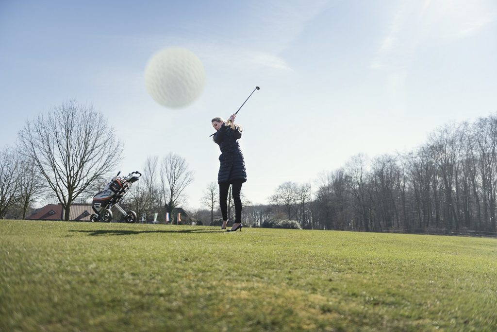 Vrouw slaat golfbal op golfbaan